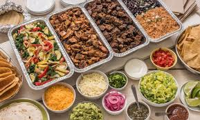 Sol Agave taco bar catering set up for a corporate event in San Clemente, with employees lining up for carne asada, pollo asado and fresh toppings